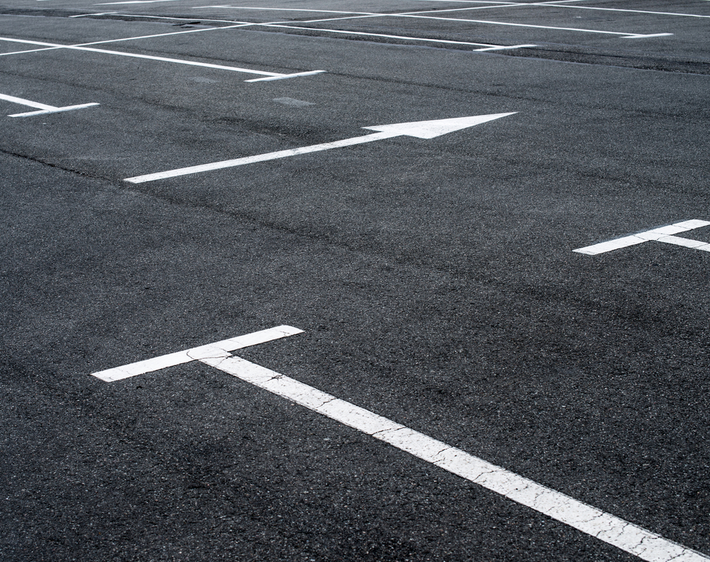 Asphalt,Surface,Of,The,Empty,Parking,With,White,Road,Marking